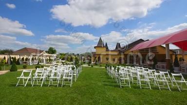 结婚通道装饰。 白色结婚椅。 户外婚礼。 婚礼设在花园里。 晴天